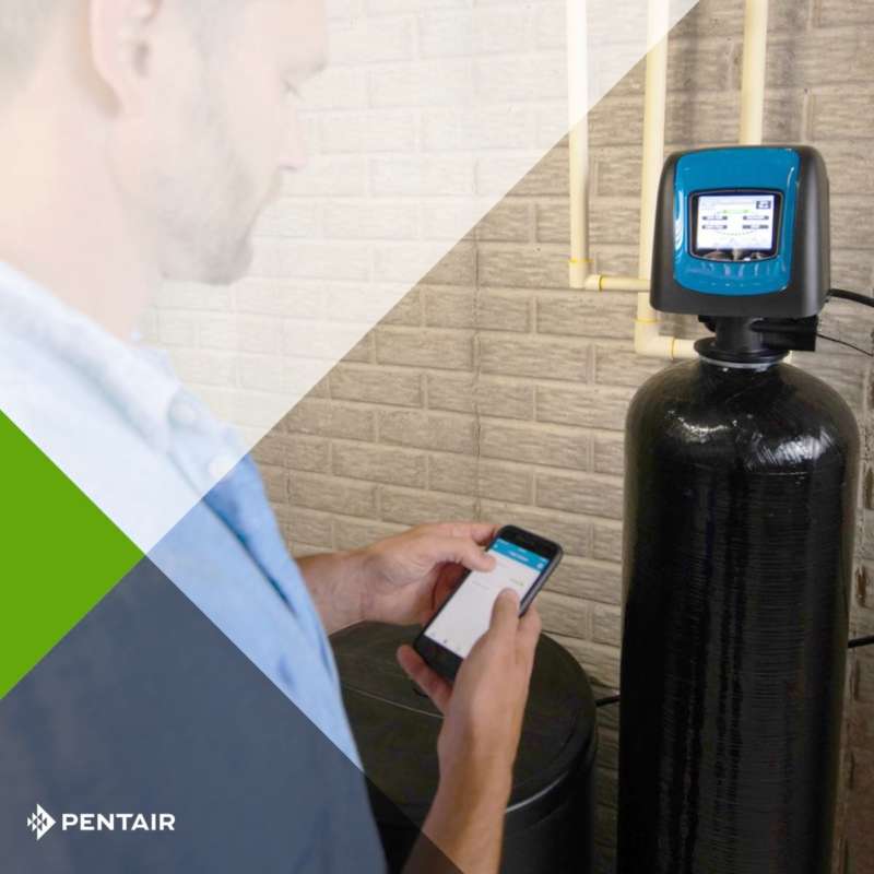 photo shows professional adjusting the water softener connected through Wi-Fi