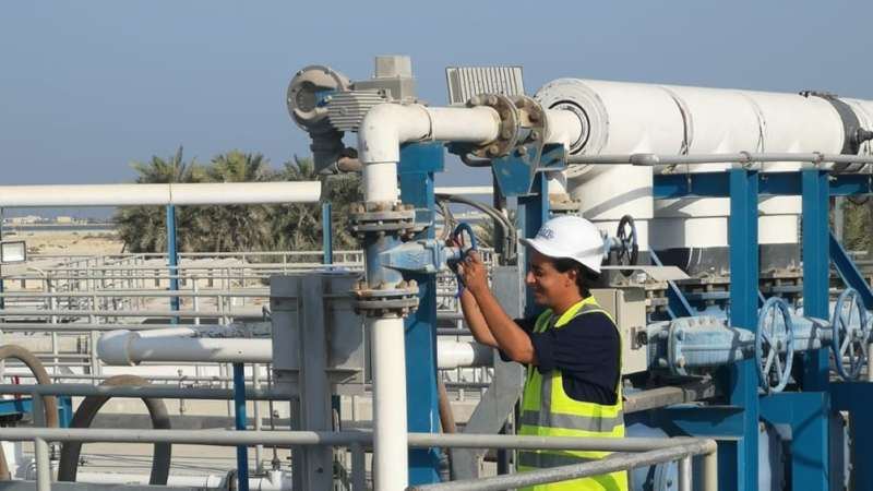 photo of an operator opening valve in a sewage treatment plant